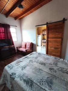 a bedroom with a large bed and a kitchen at Lo de tina in Florencio Varela