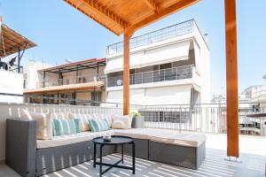 a patio with a couch and a table on a balcony at 'Elan Suites in Preveza