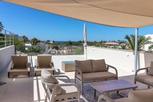 a patio with chairs and tables and a view of the ocean at Vila Castelo Parque in Ferragudo