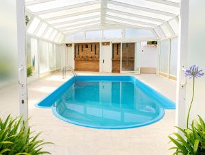 a swimming pool in the middle of a house at Cumbre- chalet con piscina cubierta y vistas al mar en Sada in Sada