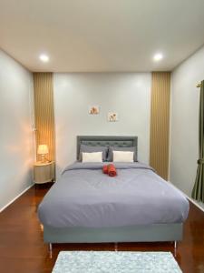 a bedroom with a bed with a red ribbon on it at Rose & Nainee House Hatyai in Ban Tha Thon