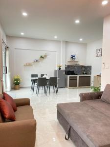 a living room with a couch and a table at Rose & Nainee House Hatyai in Ban Tha Thon