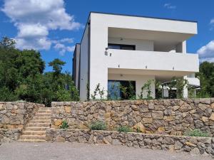 a white house behind a stone wall at Mabora in Crikvenica