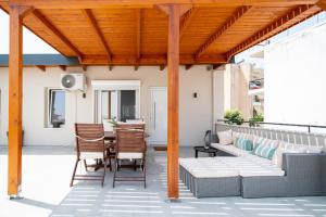 a patio with a couch and a table and chairs at 'Elan Suites in Preveza