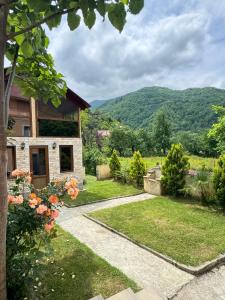 a garden with a house and mountains in the background at Red Roofs in K'eda