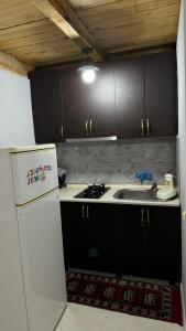 a kitchen with a white refrigerator and a sink at Red Roofs in K'eda