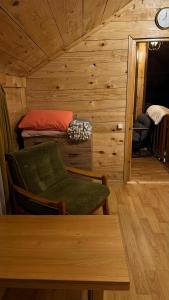 a room with a chair and a table in a cabin at Red Roofs in K'eda