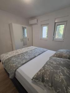 a bedroom with two beds and two windows at Mabora in Crikvenica