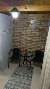 a room with a table and two chairs and a brick wall at Red Roofs in K'eda