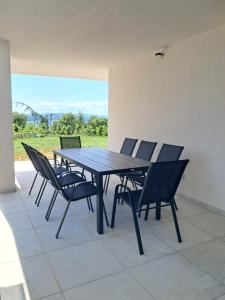 a black dining table and chairs on a patio at Mabora in Crikvenica