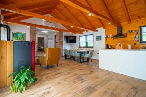 an open kitchen and dining room with wooden ceilings at Kuća za odmor Vrata Papuka in Pakrac +5 photos
