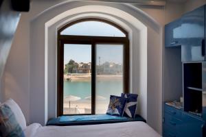 a bedroom with a window with a view of the water at VESTA - El Gouna Residence in Hurghada +41 photos