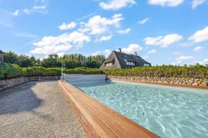 a swimming pool in front of a house at Lööws Roos in Wenningstedt