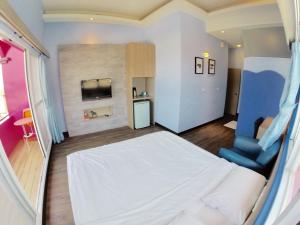 a bedroom with a white bed and a blue chair at I WoW in Xiaoliuqiu