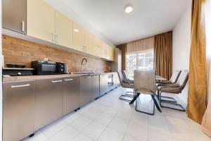 a kitchen with stainless steel cabinets and a table and chairs at Villa & Pool in Utjeha