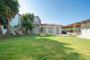 a house with a yard with a grassy yard at Meraki Villa Pelion in Kalamos