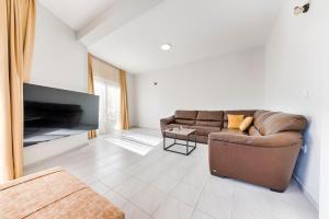 a living room with a couch and a tv at Villa & Pool in Utjeha