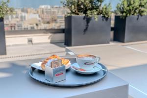 a plate of food and a cup of coffee on a table at C'est La Vie Hotel Marsascala in Marsaskala