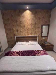 a bedroom with a large bed and a mirror at hotel happy ending in Hisār