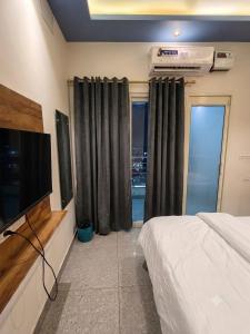a bedroom with a bed and a flat screen tv at hotel happy ending in Hisār