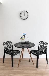a table with two chairs and a clock on a wall at Maravilha in Rio de Janeiro