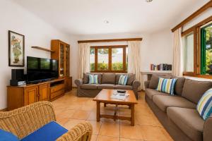 a living room with a couch and a tv at Villa Binimelis in Cacla D'or