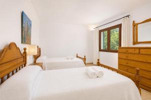 a bedroom with two beds and a window at Villa Binimelis in Cacla D'or +12 photos