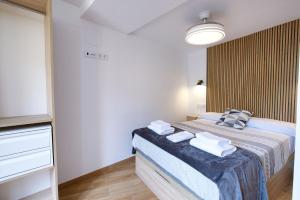 a bedroom with a bed with towels on it at Balcón de los Herreros in Cuenca