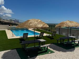 a group of chairs and umbrellas next to a pool at Hacienda del Sur in Santa Isabel