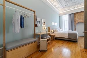 ein Schlafzimmer mit einem Bett und einem Schreibtisch in einem Zimmer in der Unterkunft SAL Collection Hotel in Aveiro