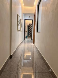 a hallway with a tile floor and a wall with paintings at hotel happy ending in Hisār