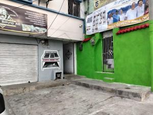 a green building with a door with a sign on it at hotel habiby32 descansa in Barranquilla