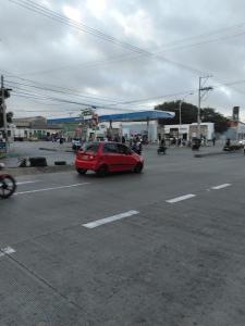 a red car is driving past a gas station at hotel habiby32 descansa in Barranquilla