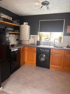 a kitchen with a washer and a sink and a dishwasher at The Flower Loft in Yeovil +7 photos