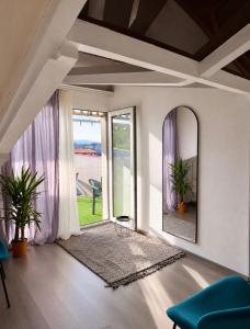 a living room with a mirror and a large window at Vernisa Hotel in Tbilisi City