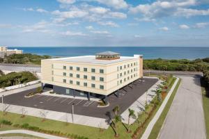 a large white building with the ocean in the background at Fairfield Inn & Suites by Marriott Melbourne Beach in Melbourne