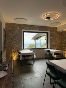 a restaurant with tables and chairs and a large window at Annina Locanda in Corciano