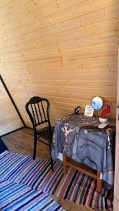 a room with a bed and a chair and a table at Căsuța Casper in Tudora +11 photos