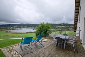 eine Terrasse mit Tisch und Stühlen und Blick auf einen See in der Unterkunft L'esca'lac in Grande Riviere