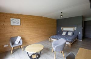 ein Zimmer mit einem Bett, zwei Stühlen und einem Tisch in der Unterkunft L'esca'lac in Grande Riviere