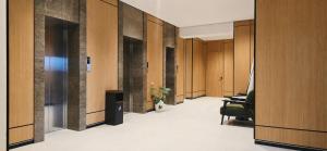 an office hallway with wooden walls and a green chair at Paziro Hotel in Dushanbe