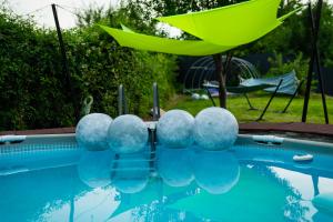 ein Pool mit blauen Bällen und einem grünen Sonnenschirm in der Unterkunft Rose Romantic in Tărlungeni