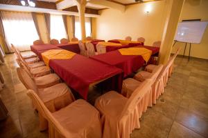 a conference room with tables and chairs and a screen at Sandton hotel kasese in Nalakonge
