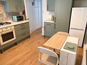 a kitchen with a table and chairs and a refrigerator at Myrtlebank in Pitlochry +7 photos