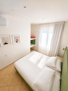 a white bed in a room with a window at Albergo Sappia in Arma di Taggia