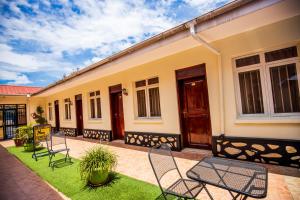 a group of chairs and tables in front of a building at Sandton hotel kasese in Nalakonge