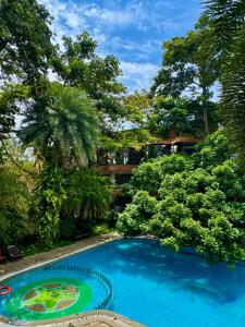 a large blue swimming pool in front of a building at Hotel Mahabs in Mahabalipuram