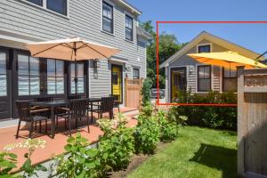 a patio with a table and chairs and an umbrella at Walk to Beach Shopping and Dining in Provincetown