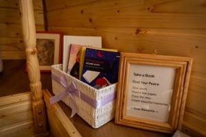 Ein Korb mit Büchern steht neben einem Bilderrahmen. in der Unterkunft Rose Romantic in Tărlungeni