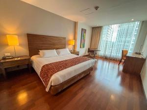 a bedroom with a large bed and wooden floors at Hotel Estelar Calle 100 in Bogotá